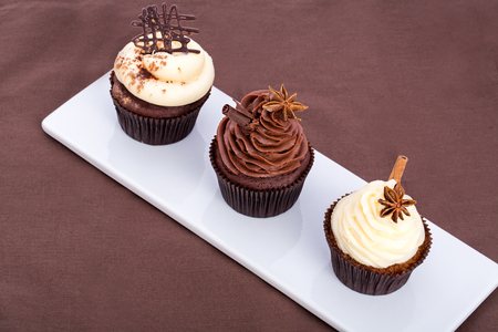 Three chocolate sweet cupcake on a brown background.の写真素材