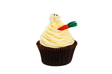 creamy sweet cupcake decorated tiny candy carrot on a white background.の写真素材