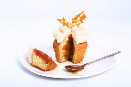 Caramel sweet cupcake cut on a white background.の写真素材