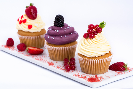 tasty cupcakes with berries, isolated on white.の写真素材