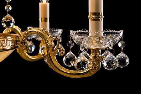Contemporary gold chandelier isolated on black background. close-up . Crystal chandelierの写真素材