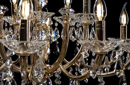 Contemporary gold chandelier isolated on black background. close-up . Crystal chandelierの写真素材