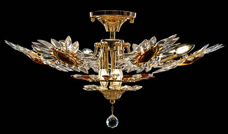 Contemporary gold chandelier isolated on black background. Crystal chandelier decorated amber crystals.の写真素材