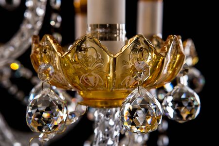 Large crystal close-up chandelier with candles isolated on black background. Luxury royal expensive chandelier for living room, Hall of celebration.の写真素材