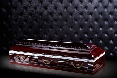 closed wooden dark brown coffin isolated on gray luxury background. casket, sarcophagus on royal background.の写真素材
