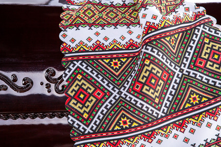 closed wooden brown coffin under the embroidered authentic cover isolated on gray luxury background.