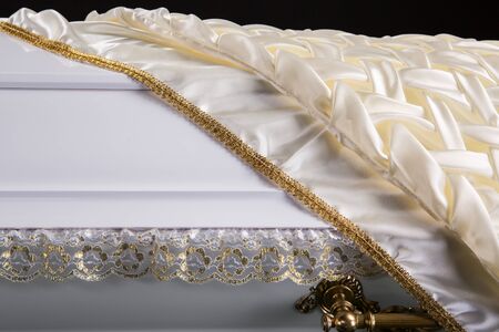 closed wooden white coffin covered with white ritual blanket isolated close-up.の写真素材
