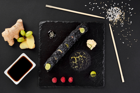 Sushi roll with crab on black shale. Roll with Grape, ginger, raspberry and soy sauce.の写真素材