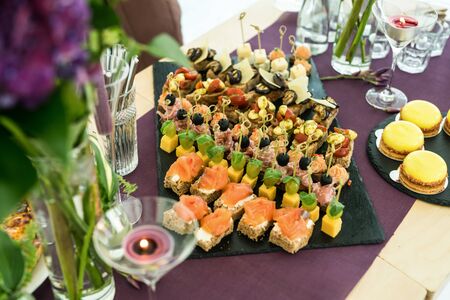 Beautifully decorated catering banquet table with different canapes and appetizers.