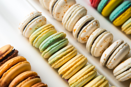 Set of different french cookies macaroons in a white box. Closeup. Coffee, chocolate, vanilla, lemon, raspberry, strawberry, pistachio, violet, rose, orange tastes macaroonsの写真素材