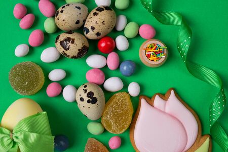 Easter quail Eggs and Candy on green Background. Vertical aerial top viewの写真素材