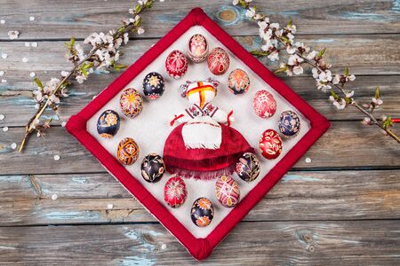 Traditional Ukrainian doll motanka or ragdoll dressed in national clothes. Ragdoll and pysankas. Easter eggs and cherry blossoms branches on rustic background. Easter concept.の写真素材
