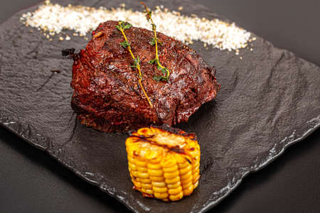 Grilled steak filet mignon served with grilled corn and thymeの写真素材