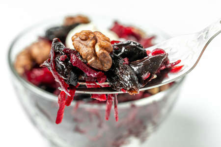 Close up, beetroot salad with walnuts and prunes on fork