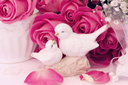 figurines wedding doves in love Valentine bouquet of pink roses on old books floral background is love tenderness vintage retro selective soft focusの写真素材