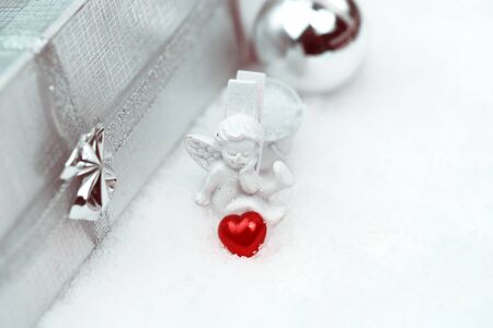 Christmas angel with a heart box with a gift selective snow soft focusの写真素材