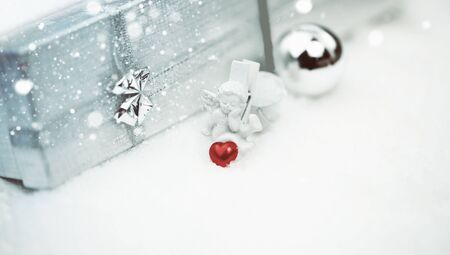 Christmas angel with a heart box with a gift selective snow soft focusの写真素材