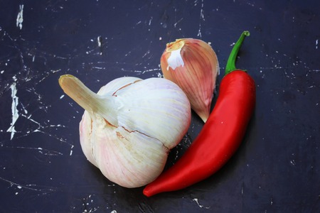 garlic and hot peppers on old wooden backgroundの写真素材