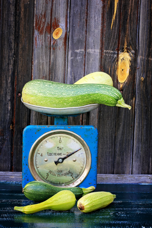vintage scales courgettes on dark wooden background rustic farm productsの写真素材