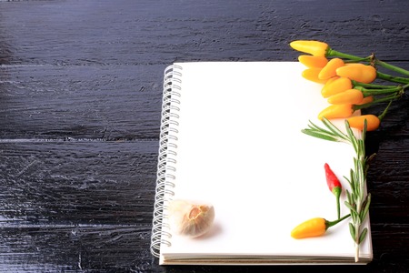 cover cookbook notebook on a black wooden background spices recipe for garlic thyme pepperの写真素材