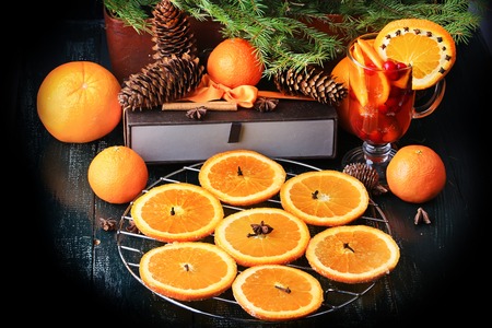 Christmas composition of preparation for drying oranges hot drink with cinnamon, anise tangerine cranberry fir vintage style on old wooden backgroundの写真素材