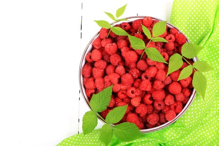 raspberries in a bowl on a white wooden background view from above a flat appearance