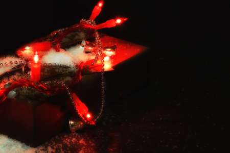 blurred Christmas winter background with gift and fir tree with lightsの写真素材