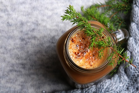 Christmas winter coffee with a spruce branch on a knitted gray backgroundの写真素材
