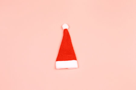 Santa Claus hat on a pink background. minimalistic christmas scandy background with empty place for textの写真素材