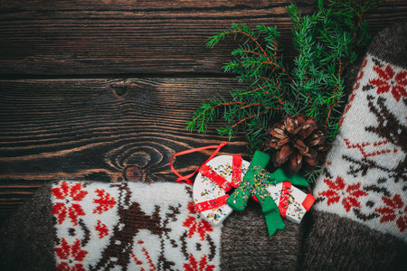 Christmas tree pine cone knitted mittens on wooden backgroundの写真素材