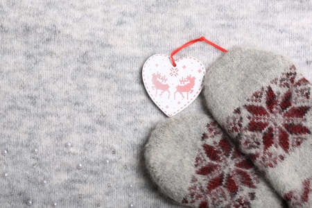 Warm Christmas. Knitted mittens and a Christmas tree toy. New Year holiday backgroundの写真素材