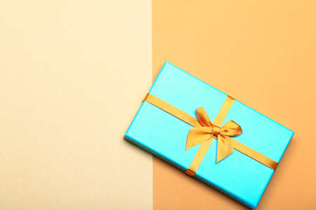 turquoise gift box on yellow paper background