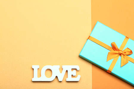 Valentine day love concept. Word love made from wooden letters on yellow paper backgroundの写真素材