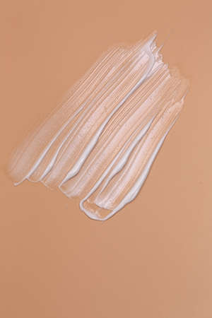cosmetic natural pastel concept. The texture of liquid cream with a cosmetic brush on a beige...