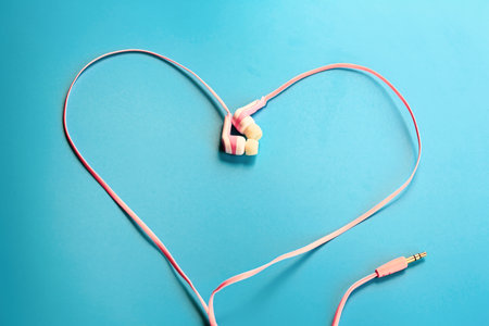 Love music concept. Pink headphones in the form of a heart on a blue background.の写真素材