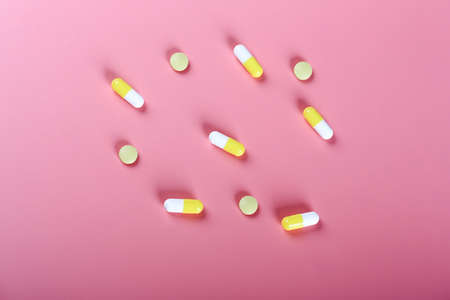 yellow pills pills on a pink background