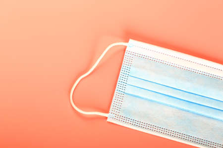 blue medical mask on peach background