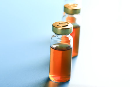 vaccine bottles on a blue background. medical concept. Very shallow depth of field. illumination across the frameの写真素材