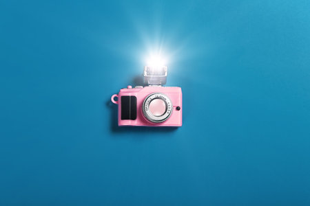 small pink camera with flash on blue backgroundの写真素材