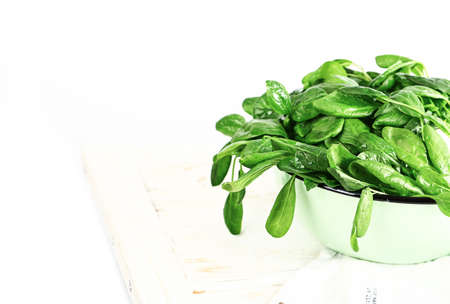 spinach in a plate on a white table. Healthy wholesome food. Vegetarian food. Selective soft focusの写真素材