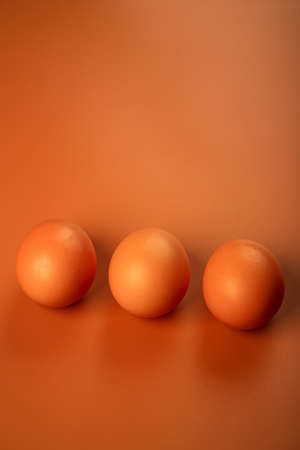 chicken egg on a beige background. Three brown eggs. Easter minimalistic concept.の写真素材