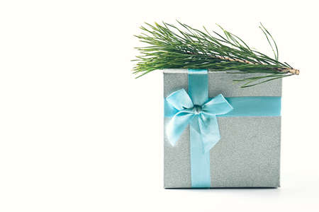 Spruce branch and gift box on a light background. Christmas minimalism.の写真素材