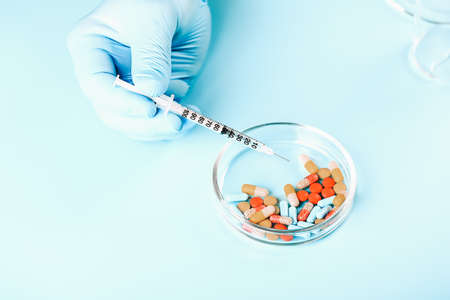 Abstract medical background. doctors hands in medical gloves hold multicolored pillsの写真素材