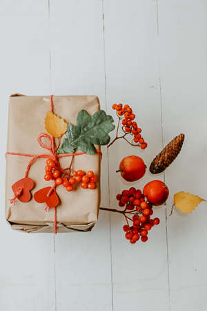 box with autumn gift wrapped in kraft and tied rope with hearts. Eco-friendly biodegradable packaging. DIY Wrapped Thanksgiving Giftの写真素材