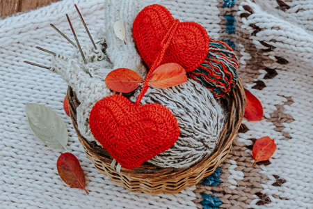 Autumn knitting of warm clothes. Woolen balls of knitting needles knitted hearts. Self-made things with love. Idea for handmade giftsの写真素材