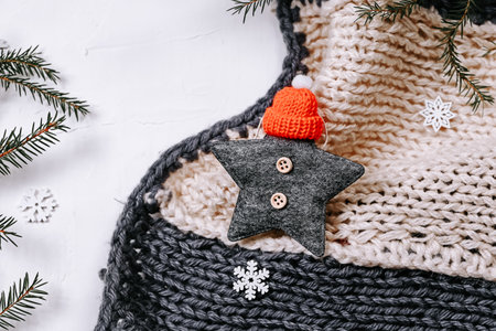 Minimalistic Christmas background. Knitted blanket and spruce branches and snowflakes on a white backgroundの写真素材