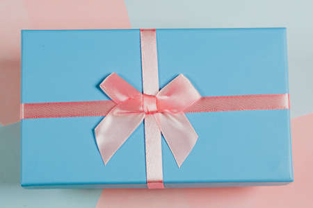 Christmas minimalistic concept. Gift box tied with a ribbon with snowflakes. Flat style, top view, place for textの写真素材