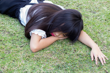 Asian girl lying on green grassの写真素材