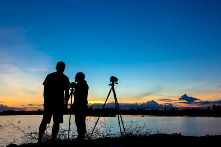 Silhouette photographers with sunset backgroundの写真素材