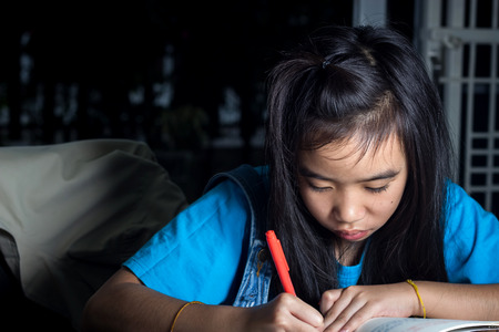 ten-year old asian schoolgirl doing homework.の写真素材
